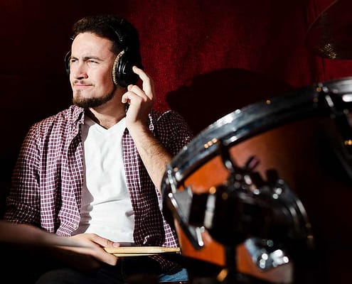 Choosing the Best Headphones for Audio Production & Mixing Drummer wearing headphones